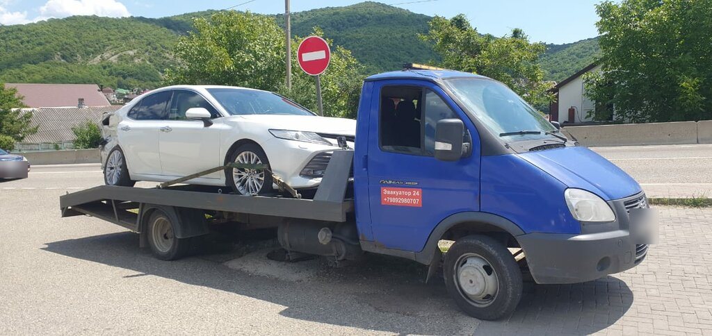 Эвакуатор с легковым автомобилем на фоне гор Адыгеи